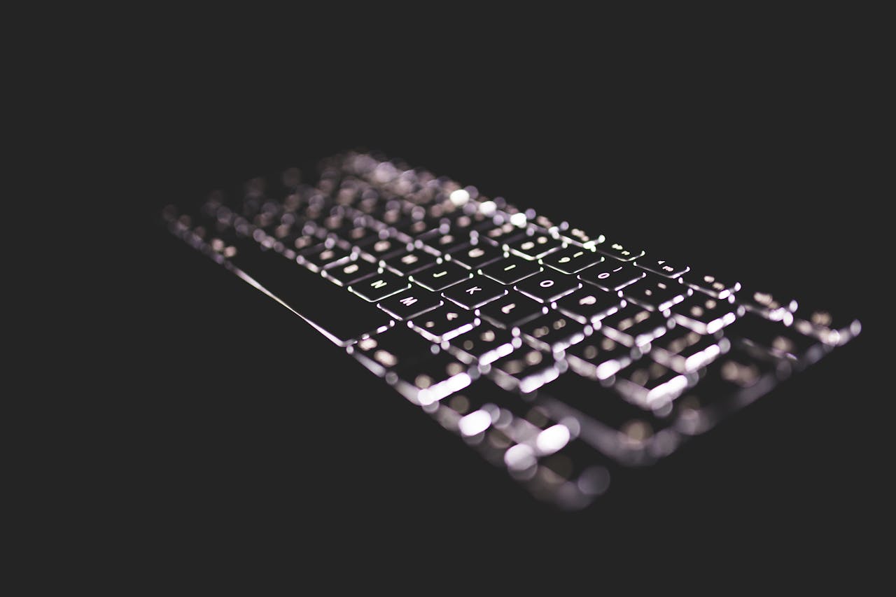 Close-up of a glowing keyboard with backlight on a dark background, emphasizing technology.